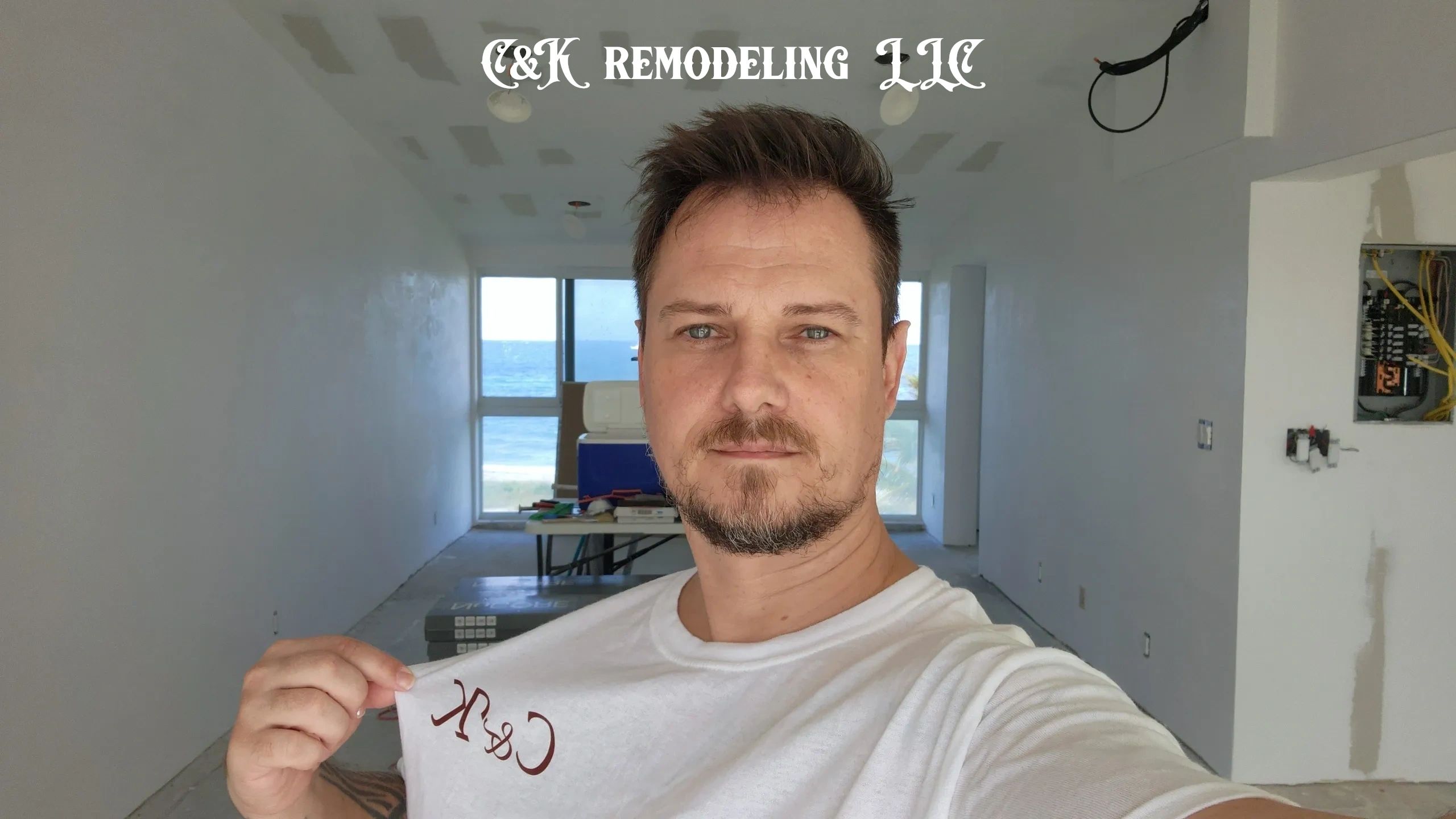 Charlie showing the C&K Remodeling shirt on a project site